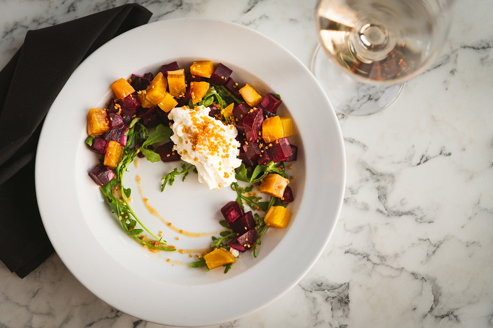 A white plate featuring a vibrant salad made from seasonal and local produce sourced in Newportjpeg