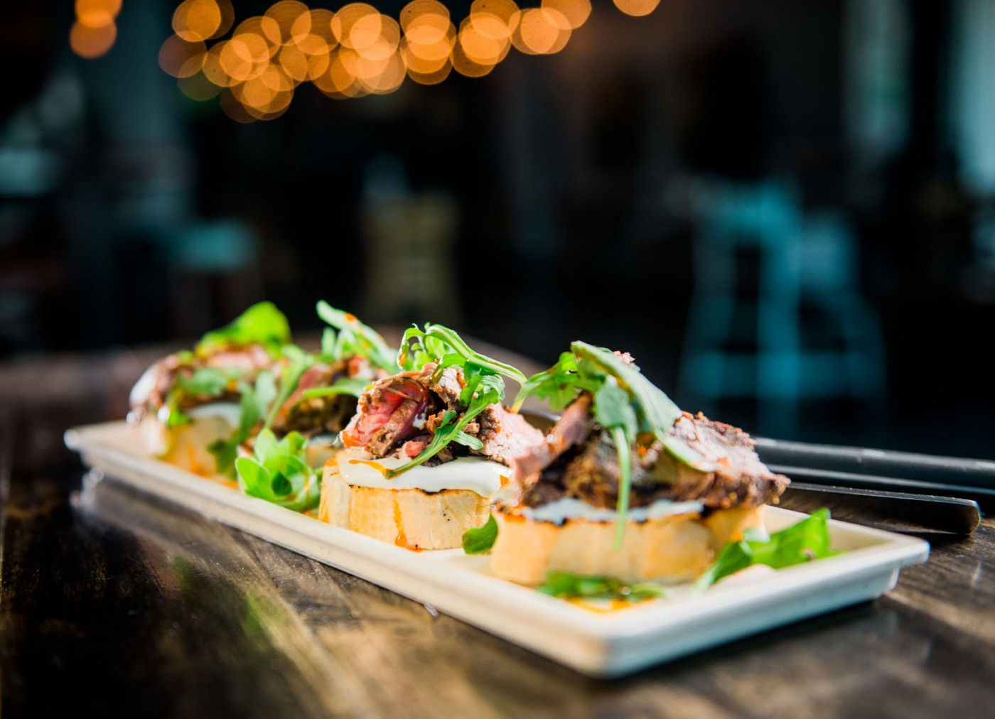 A gourmet plate featuring succulent meat and fresh greens, elegantly presented for Myril catering at a wine bar.